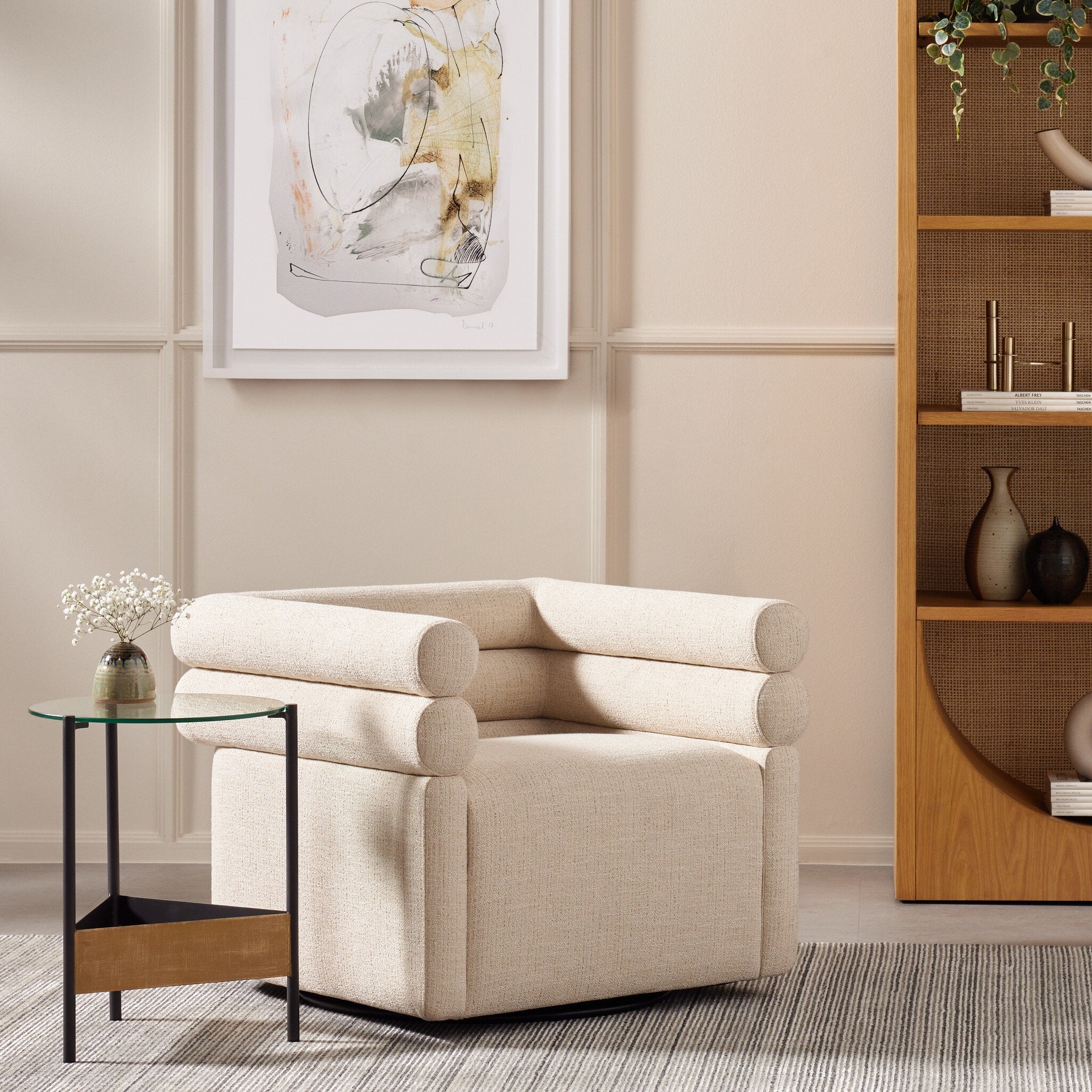 Evie Swivel Chair - styled with neutral artwork and a glass side table