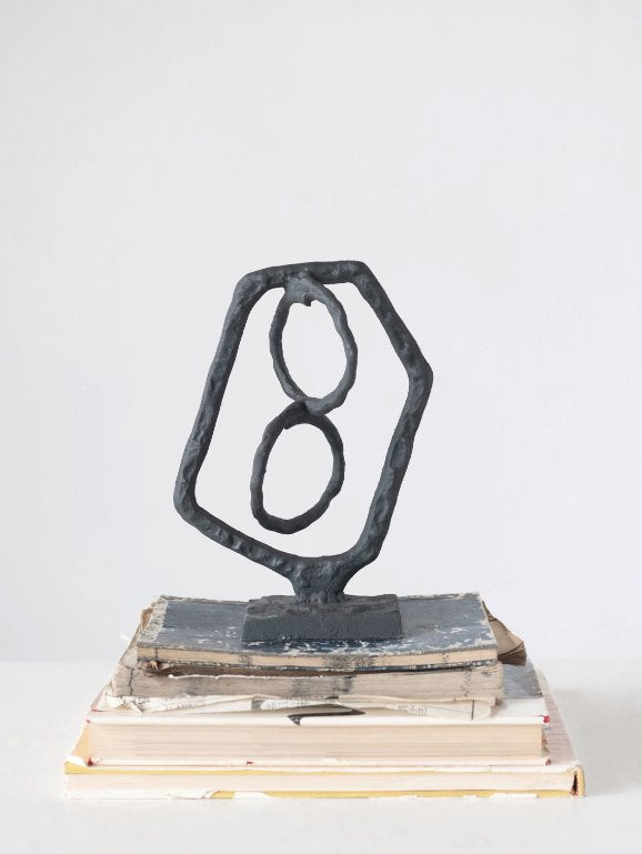 Cast Iron Abstract Decor Object: Bring a piece of abstract art into your home with this cast iron sculpture. This decor object adds an element of design to a table top, bookshelf, or any space that needs a little something extra.