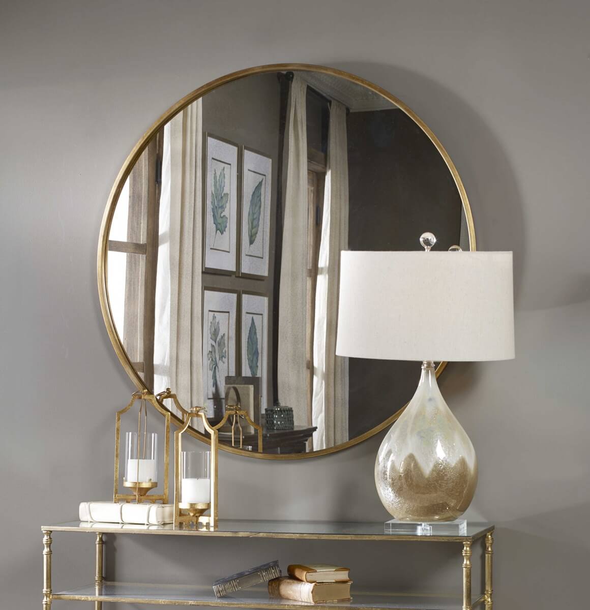 Junius round mirror in gold leaf styled with other metallic accents