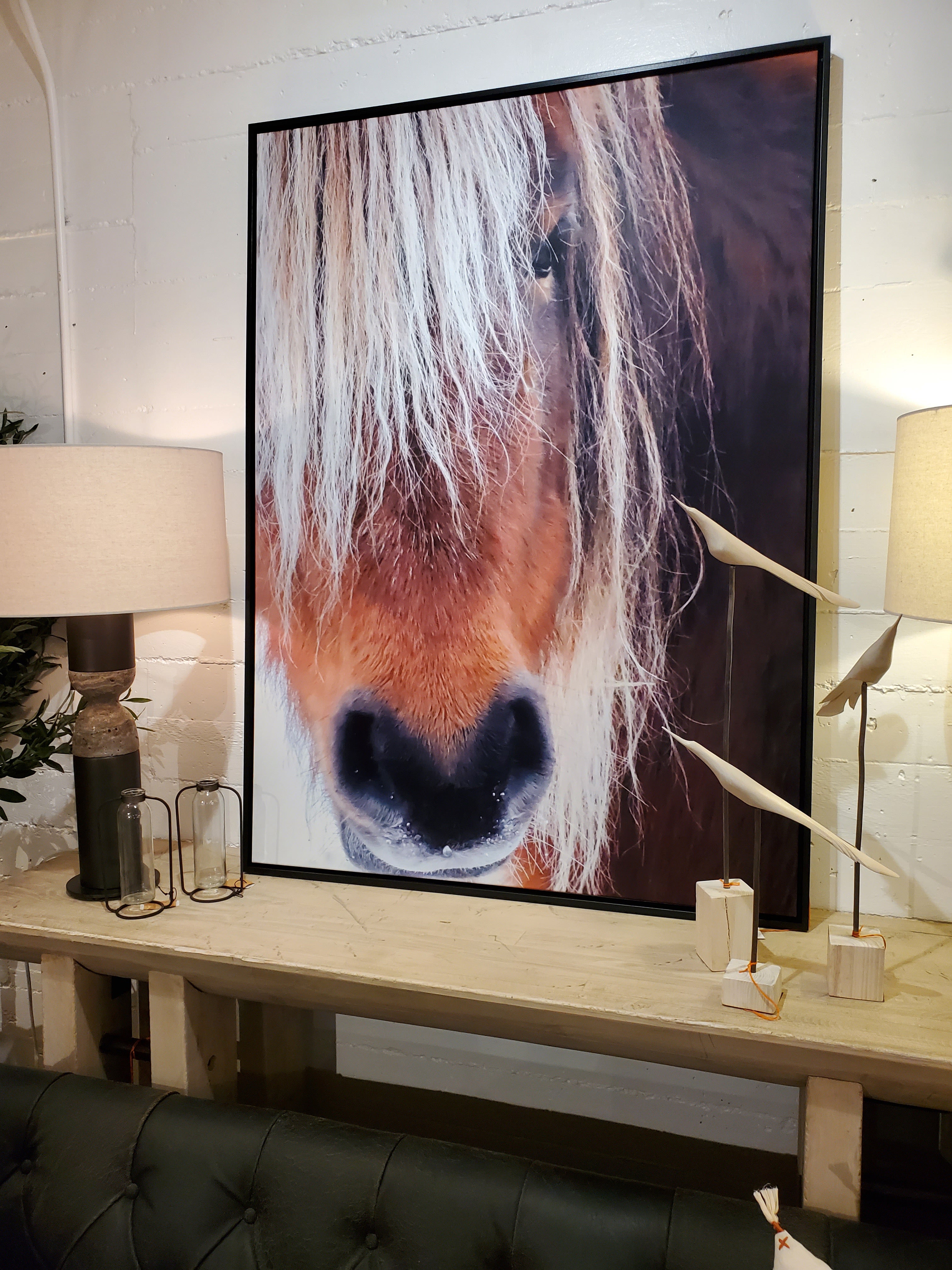 Poni framed artwork in ebony finish wood frame, styled behind a dark sofa